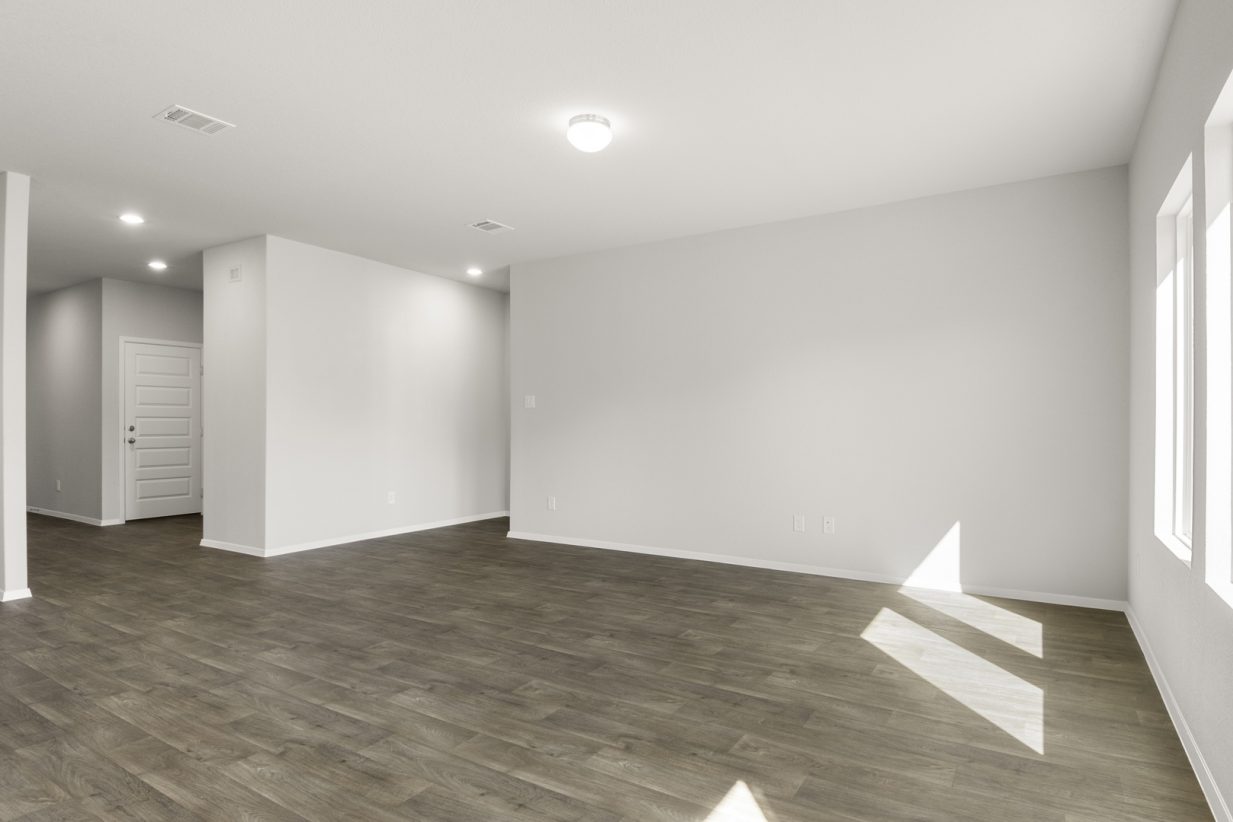 Image of a living room with brown wood-look flooring, grey walls and white trim