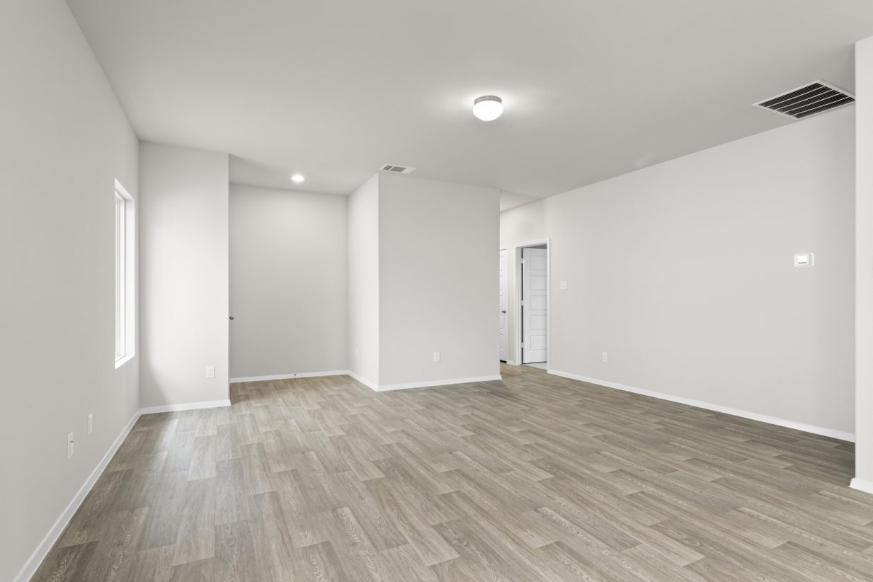 Image of a living room with cream walls, light brown vinyl flooring, a window and a white front door