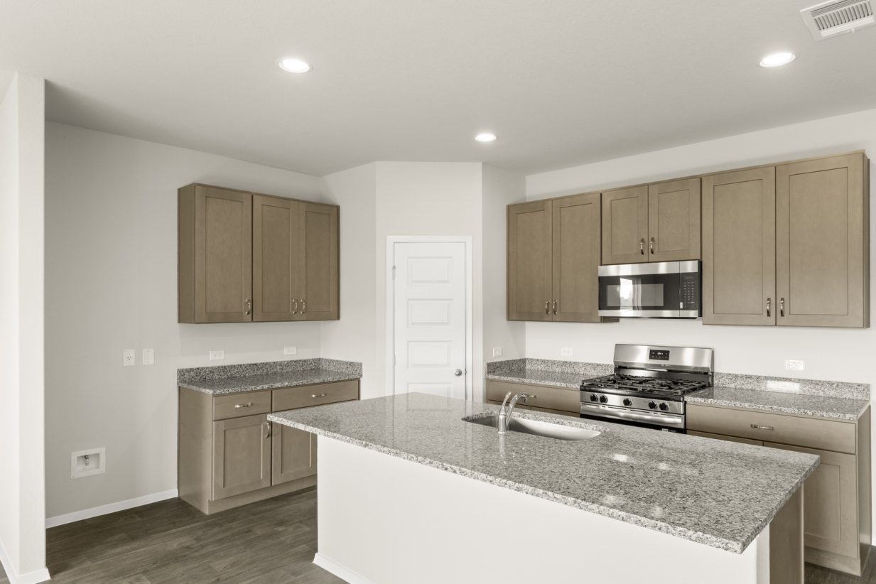 Image of a kitchen with a center island, granite countertops, light brown cabinets and a black appliance package