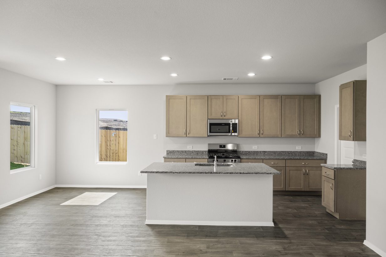 A kitchen with gray marble countertops, gray cabinets, vinyl flooring, a central island, and steel kitchen appliances.