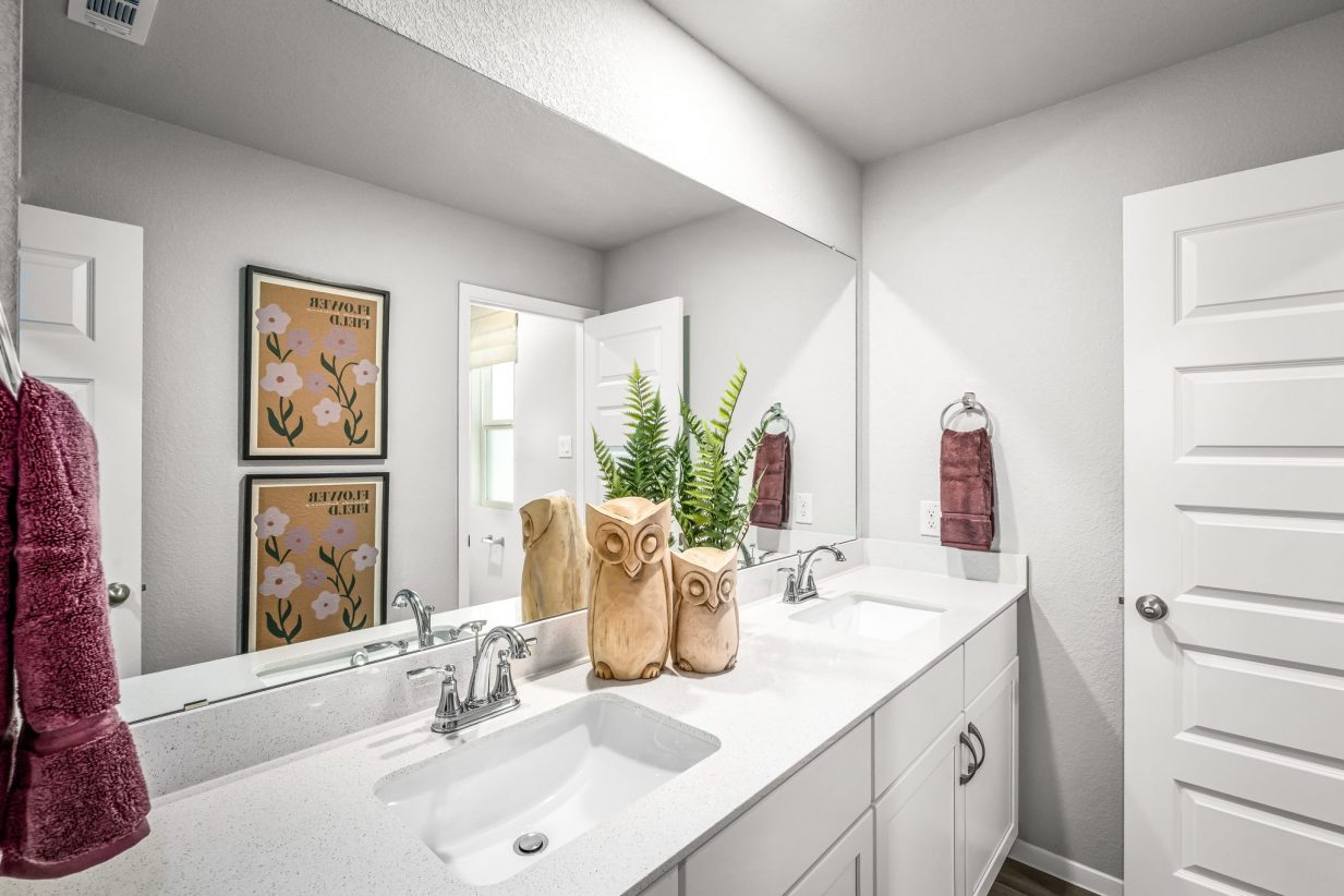 An image of bathroom with a dual vanity with a white countertop,