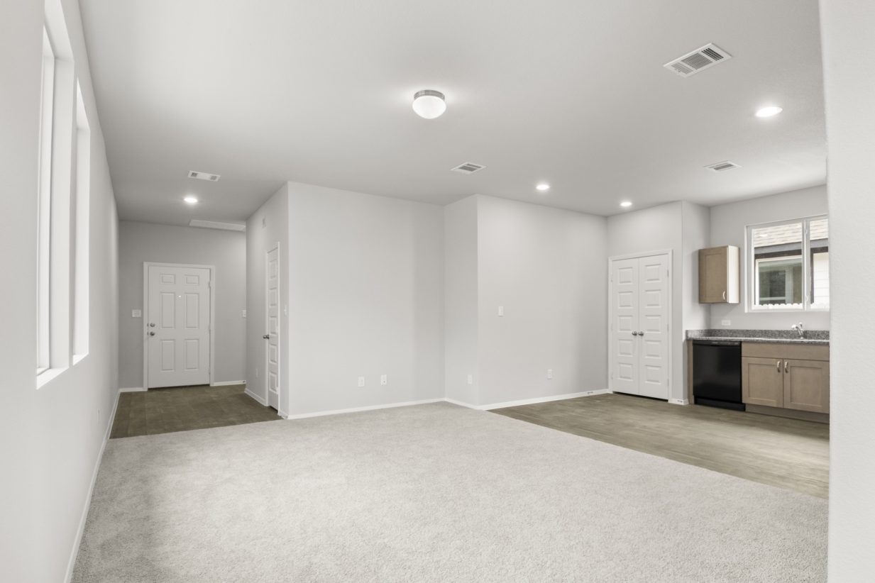 Image of a living room with light tan carpeting and light grey walls