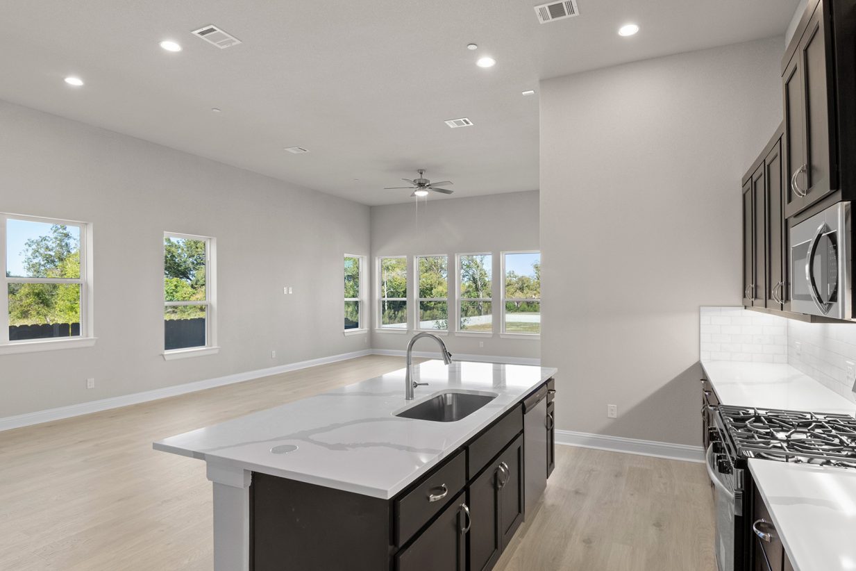 Image of kitchen with dark cabinets and light flooring with a island