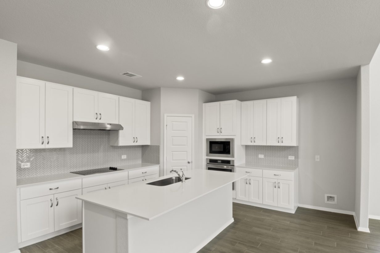 Image of a kitchen with a white center island and cabinetry with stainless steel appliances