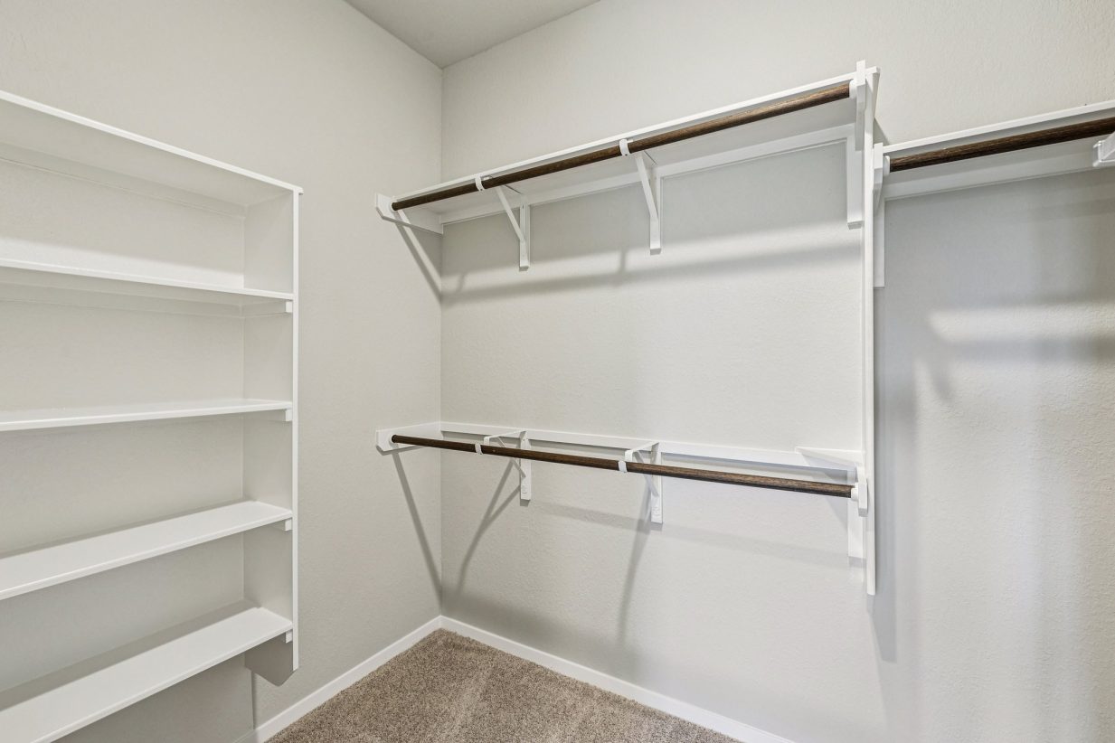 Image of a primary closet with white shelves