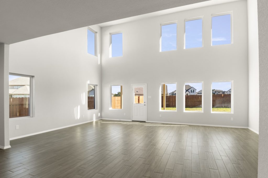 Image of a two story home living room with a high ceiling and windows