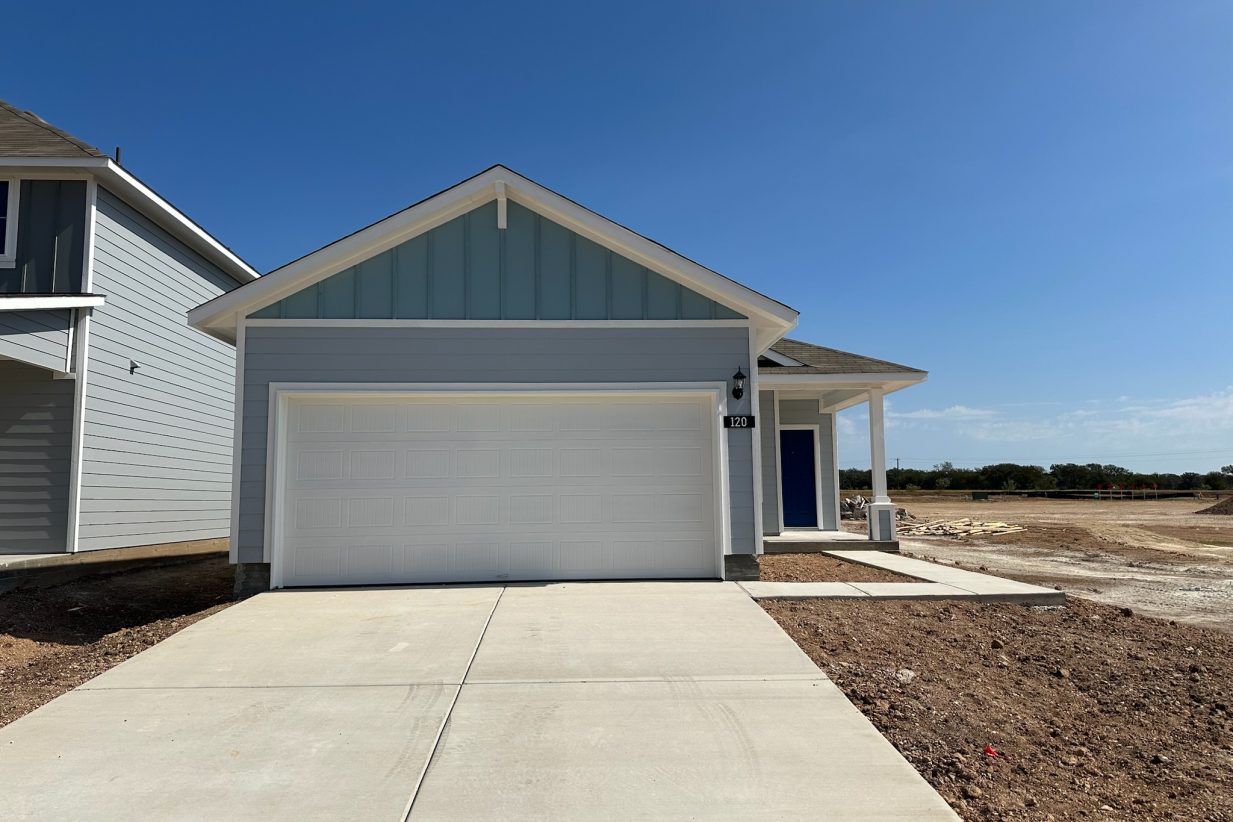 Image of one story blue home with white trim and garage and blue front door