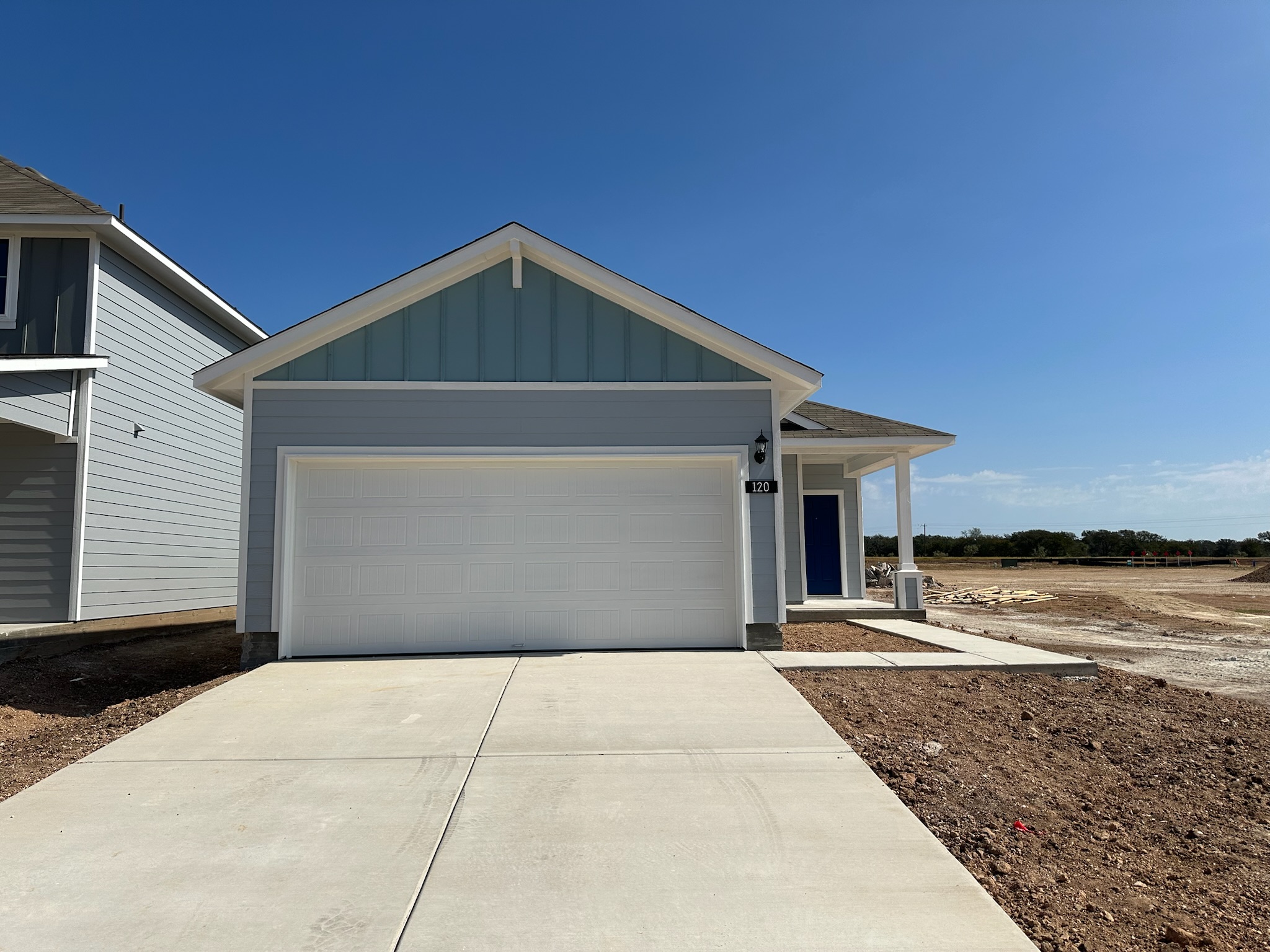 Image of one story blue home with white trim and garage and blue front door