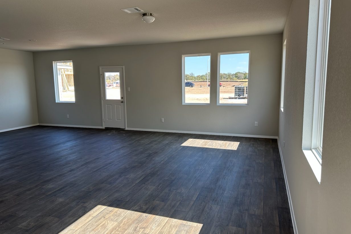 Image of home living and dining areas with wood-look floors, white walls, and windows