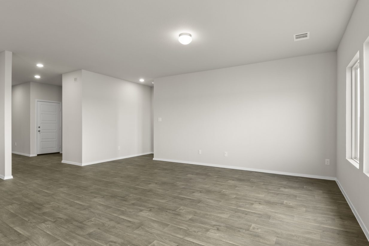 Image of a one story home living room with dark wood-like flooring and light grey walls