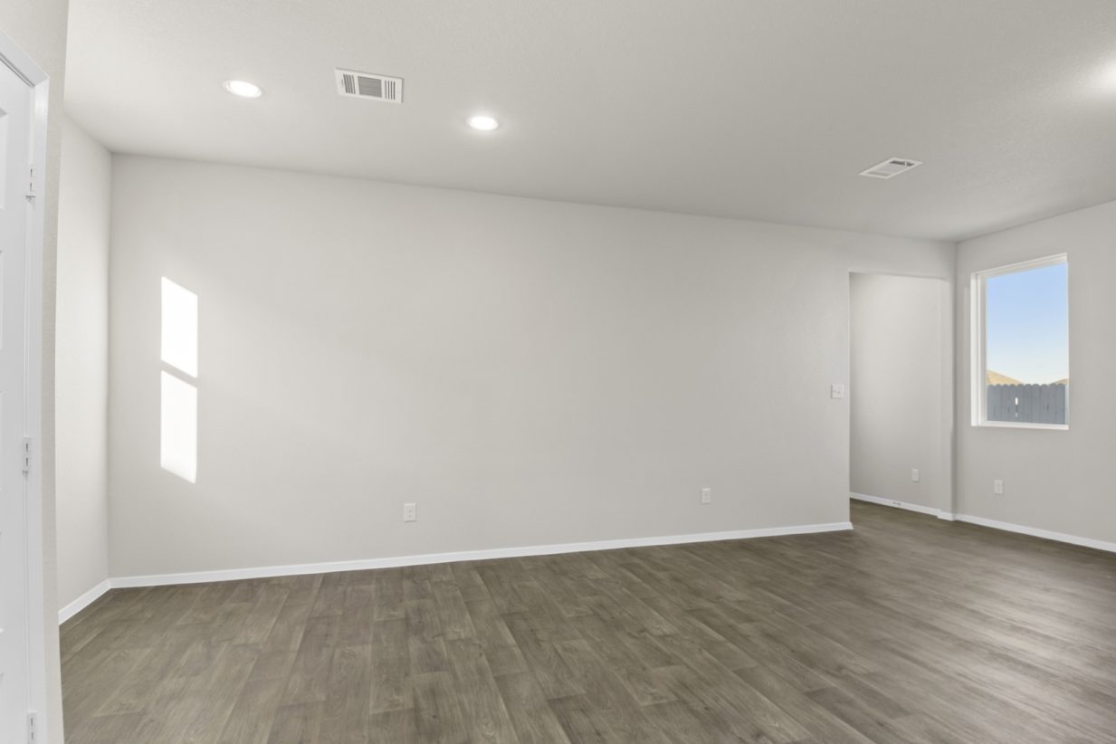 Image of a dining room with dark brown flooring and light grey painted walls