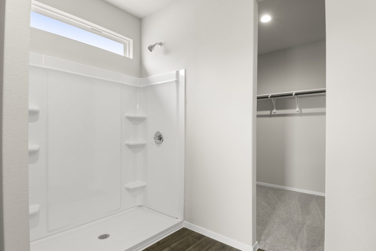 Image of primary bathroom with a standing shower and walk in closet