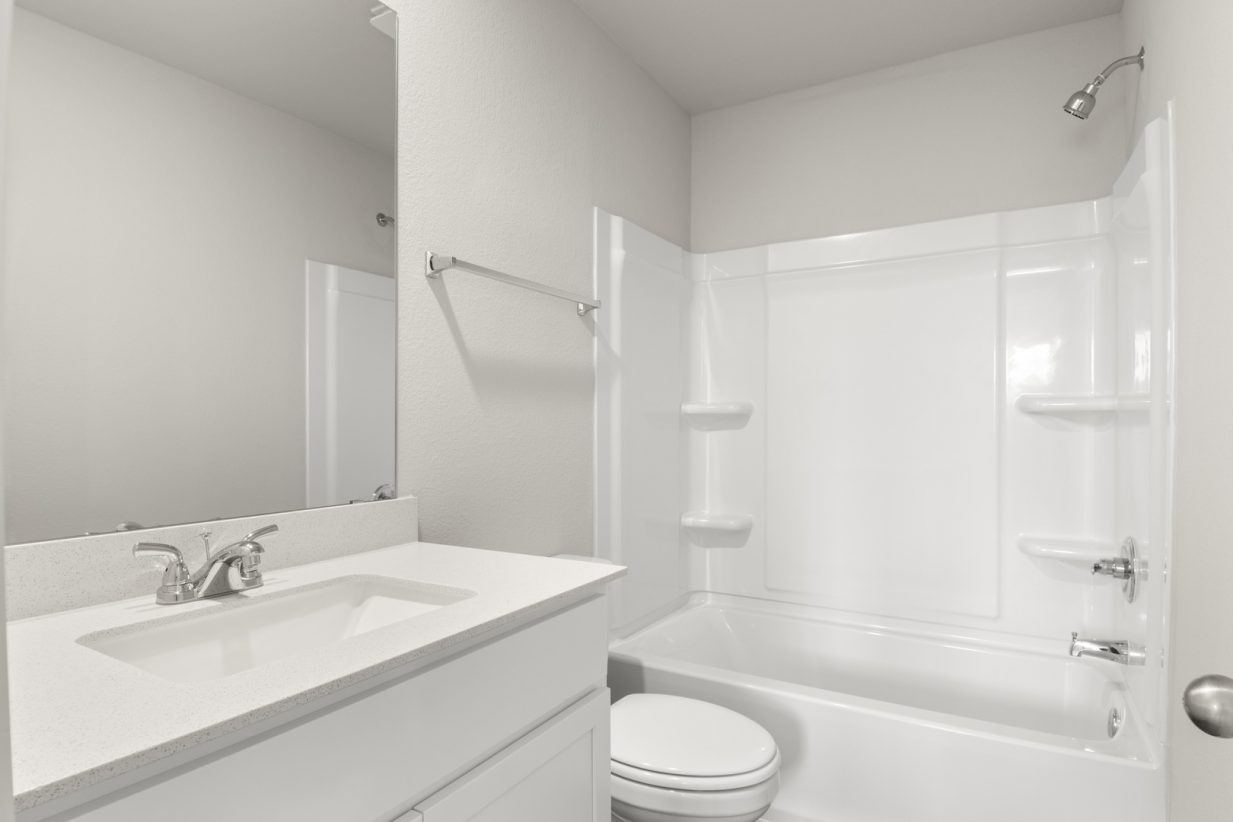 Image of bathroom with white cabinets and a mirror with a vanity and a shower with a tub