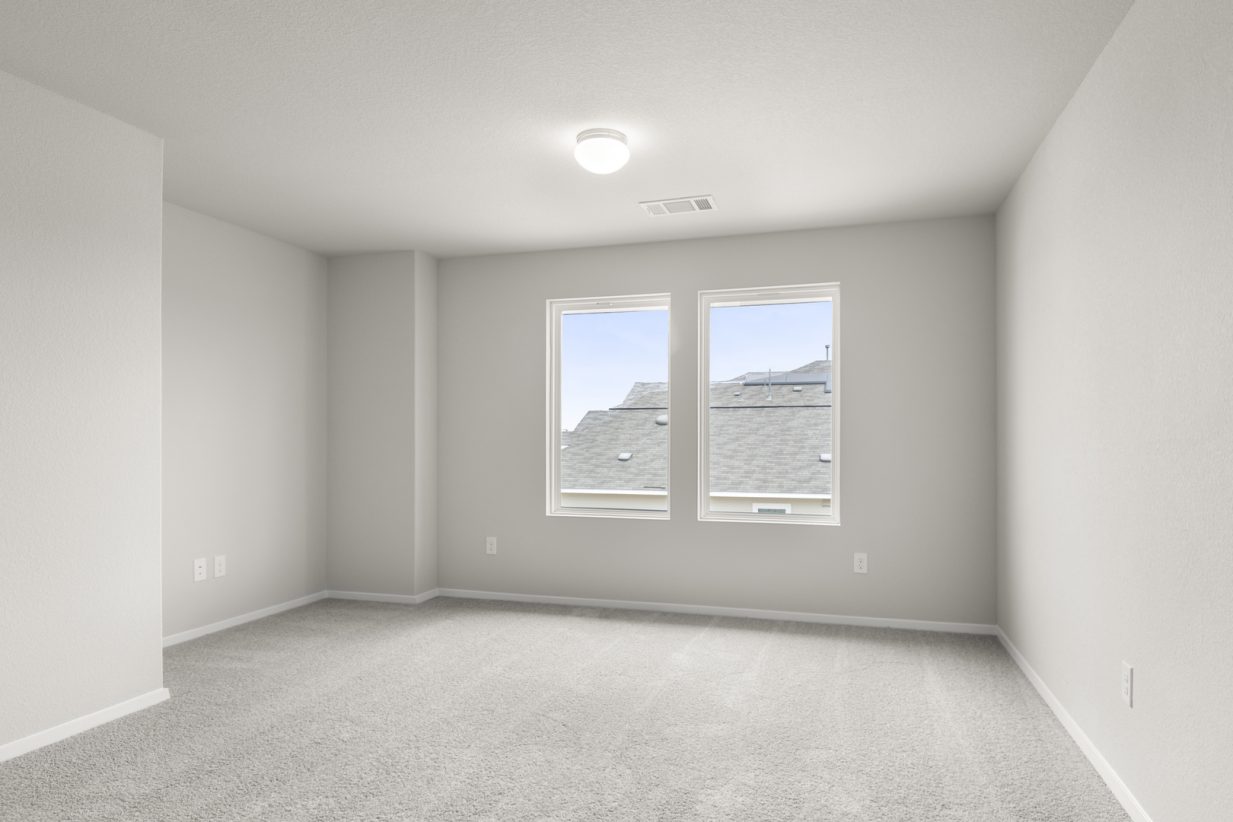 Image of upstairs flex space with light grey carpet and walls and two windows