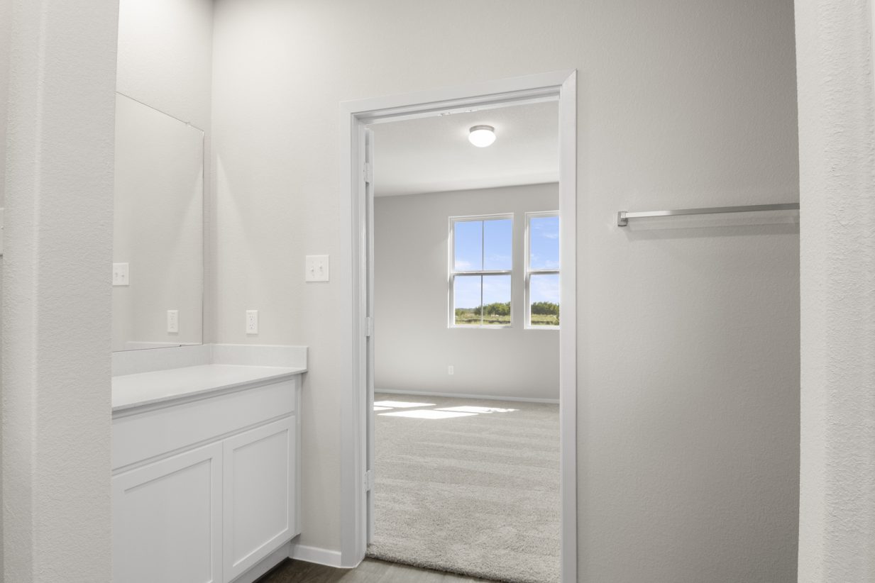 Image of home primary bathroom looking into bedroom with a window
