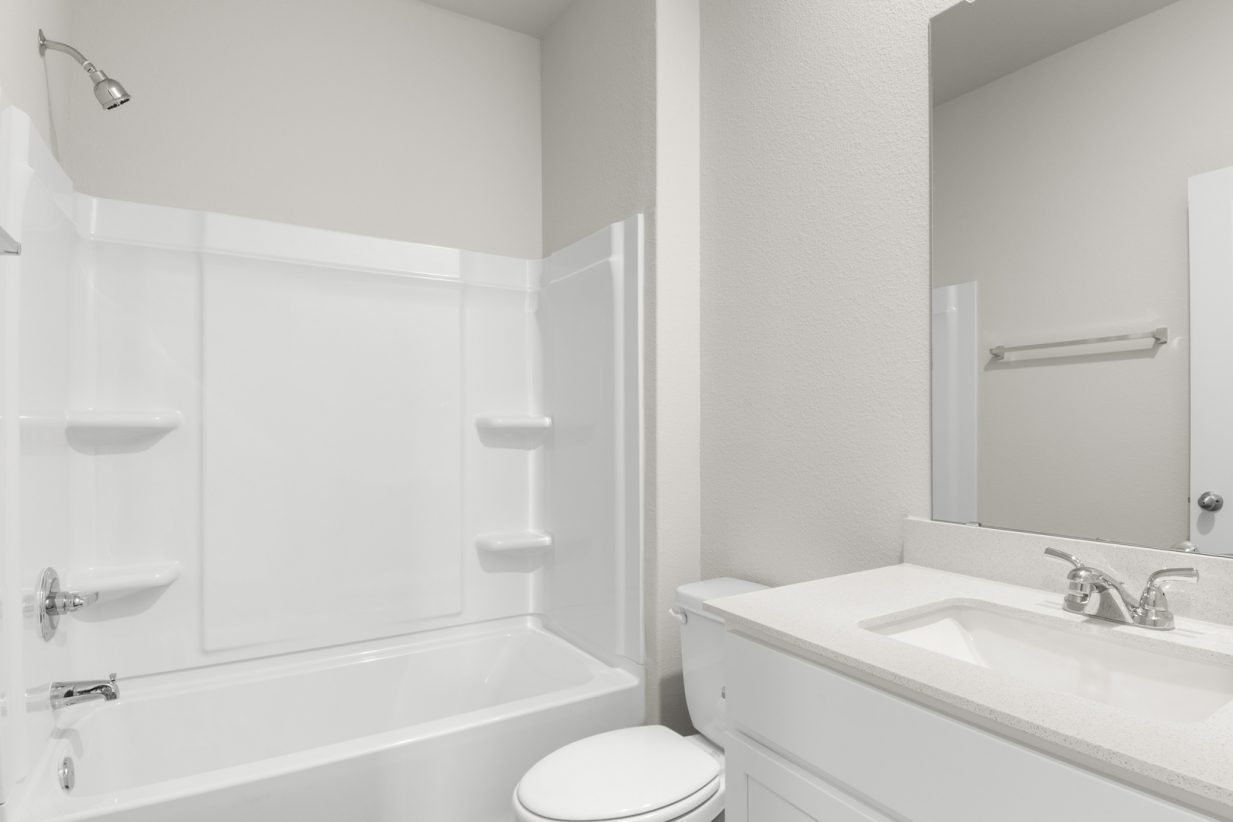 Image of second bathroom with white cabinets and mirror with a vanity with a tub and shower