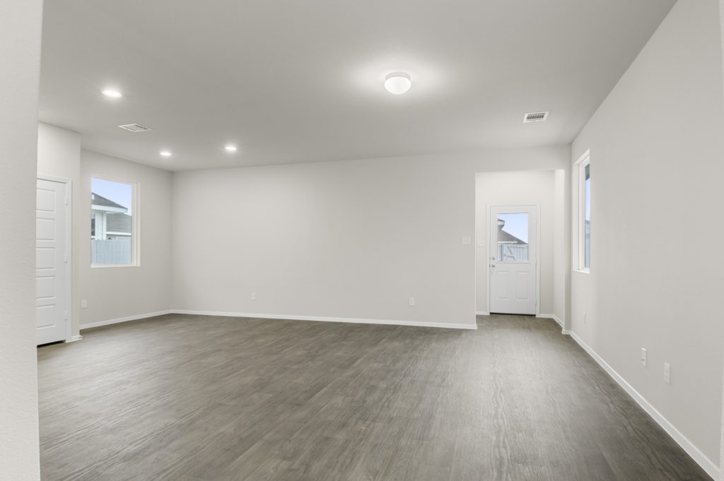 Image of a one story home living room with brown flooring and white walls