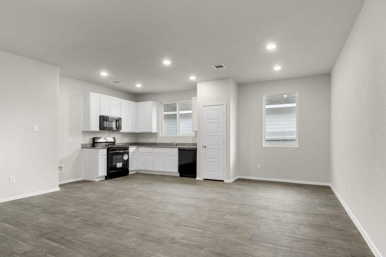 Image of a one story home dining room with a kitchen in the distance
