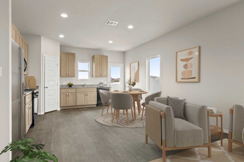 Image of a staged kitchen and dining area with a round scandinavian dining table with chairs, plates, and wall art