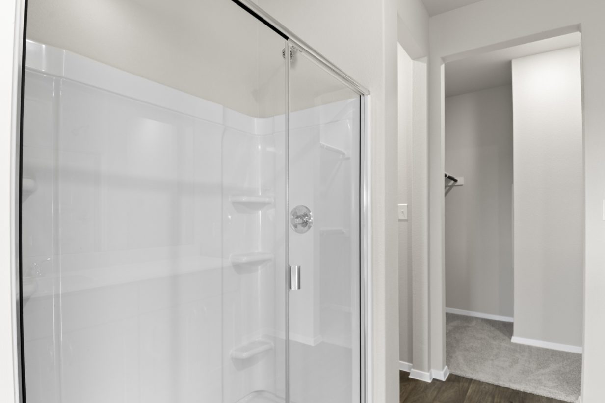 Image of primary bathroom with a walk-in shower and connecting walk-in closet