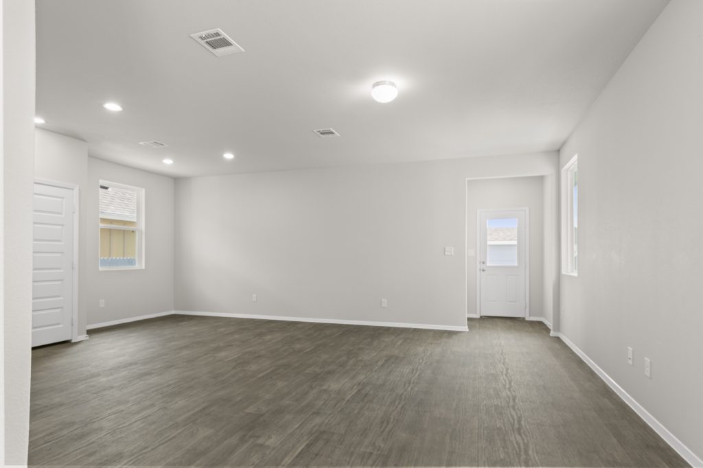 Image of a living room with dark vinyl flooring and light grey painted walls