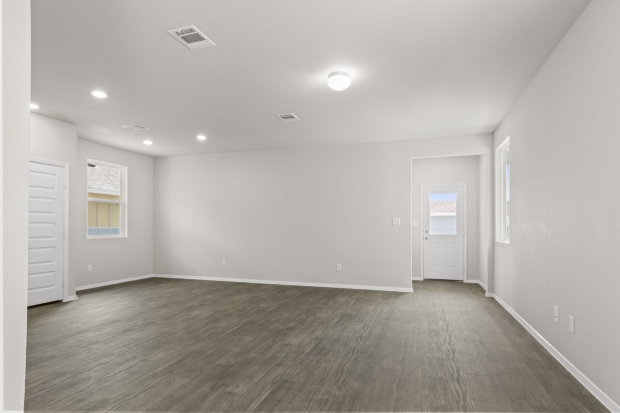 Image of a living room with dark vinyl flooring and light grey painted walls