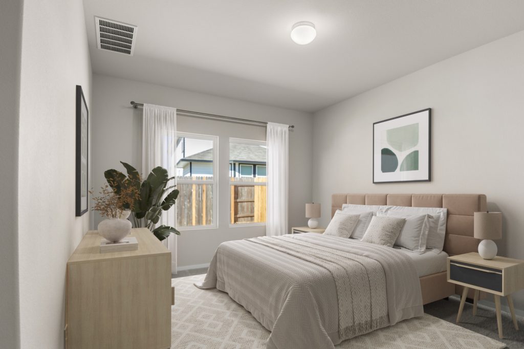 Image of a staged primary bedroom with a tan bed frame, white bedding, a light wooden dresser, and side tables with lamps