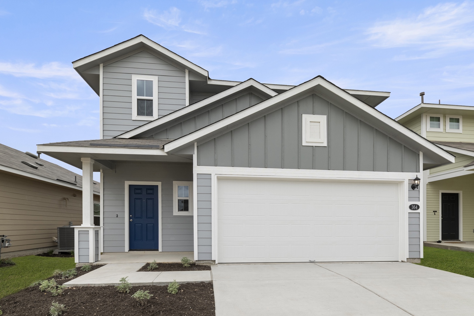 Image of a grey two story house with white trim, a white garage, a cement driveway and a blue front door