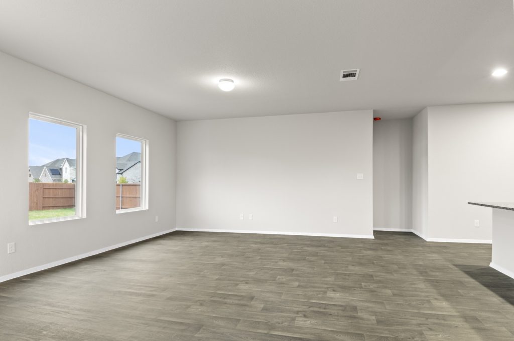 Image of a living room with dark brown vinyl flooring with light grey walls and white trim