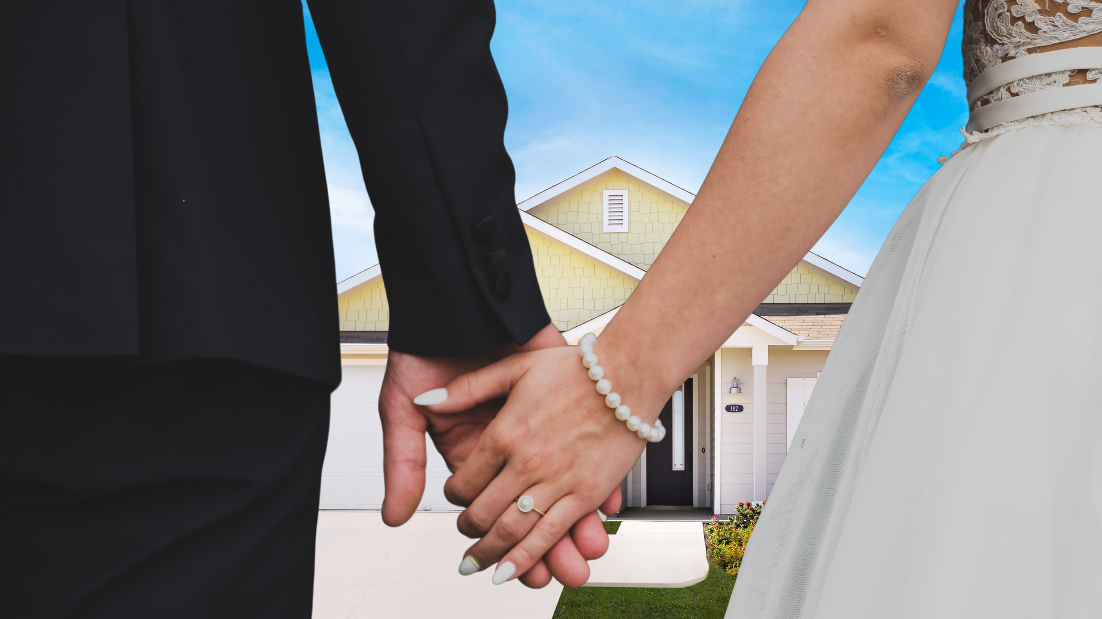 An image of a bride and groom holding hands in front of a black and white house.