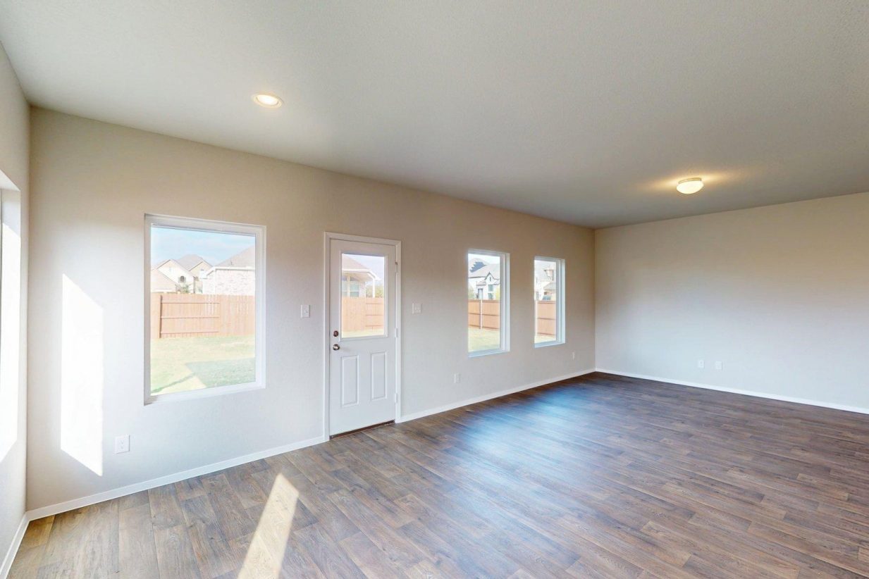 Matterport snapshot of a living room area with brown wood-look flooring and beige walls with windows