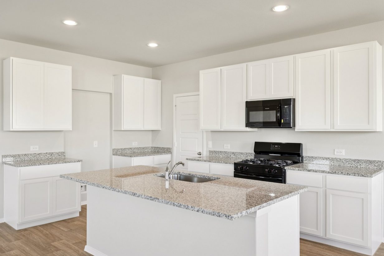 Image of a kitchen with white cabinets, granite countertops, and black apliances