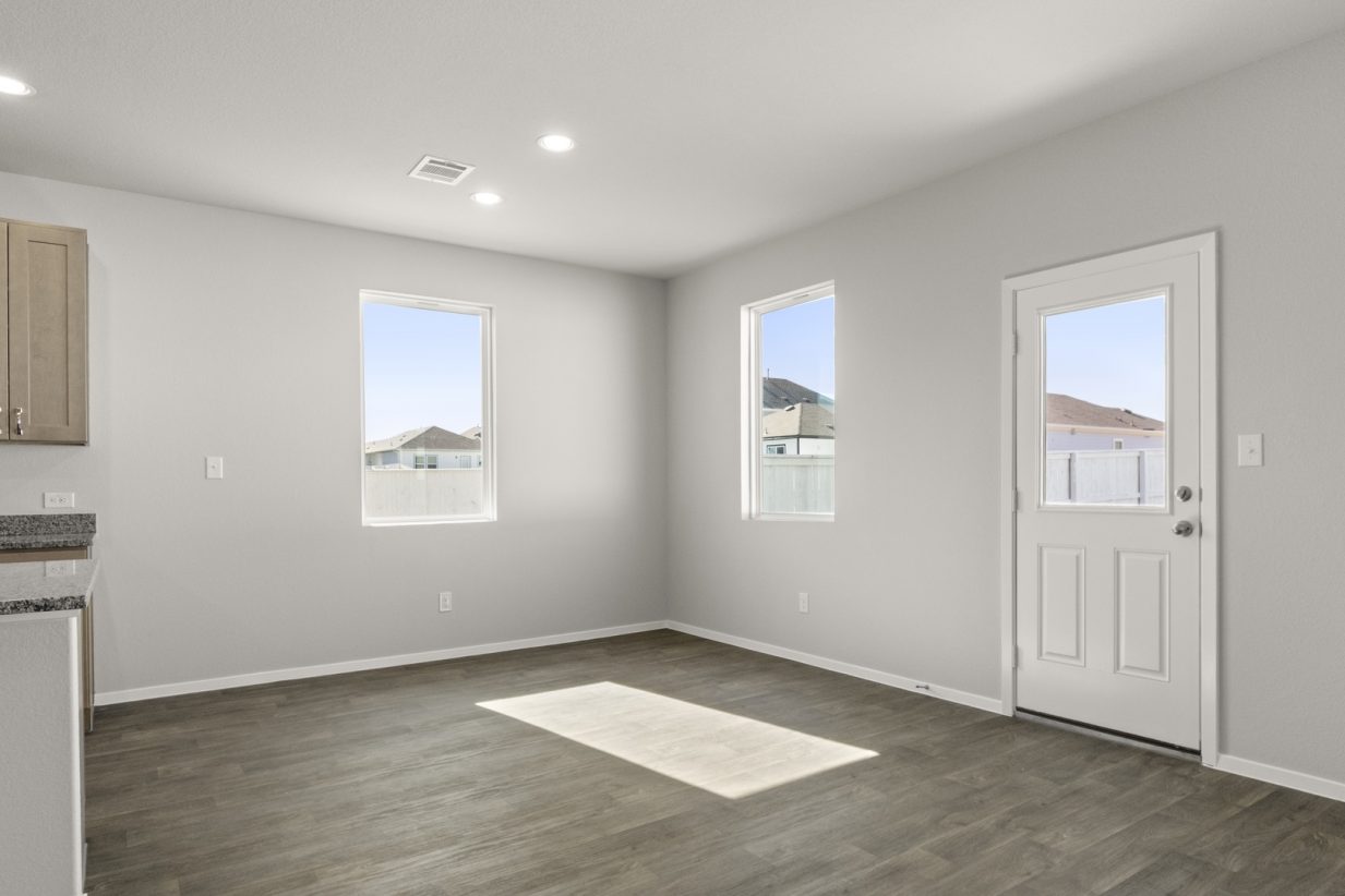 Image of a dining room with dark vinyl flooring, light grey walls and two large windows