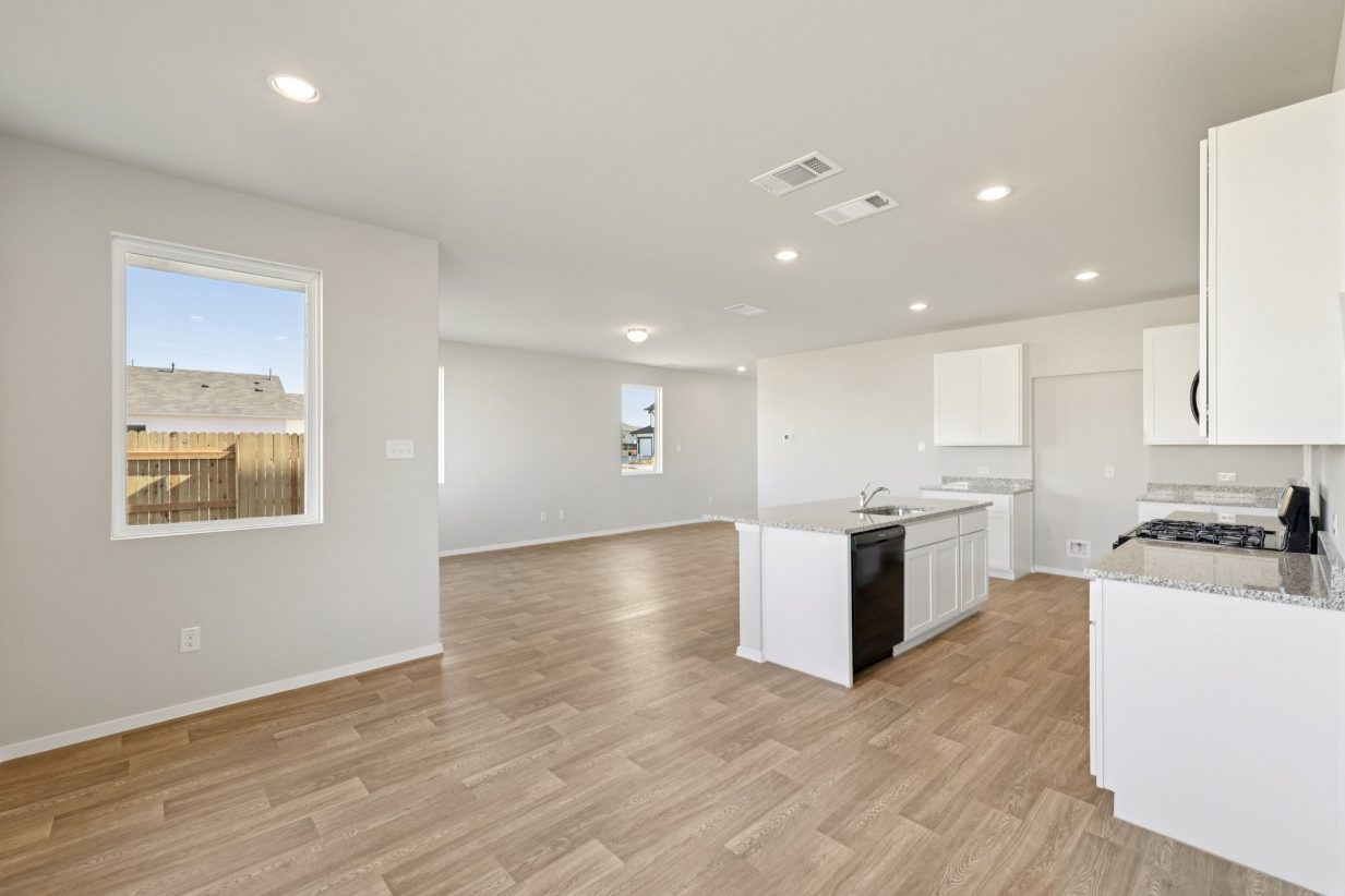 Image of a dining area with grey walls, vinyl flooring, and a white cabinet kitchen
