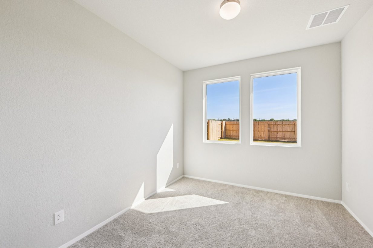 Image of downstairs study room with beige walls, carpeting and windows