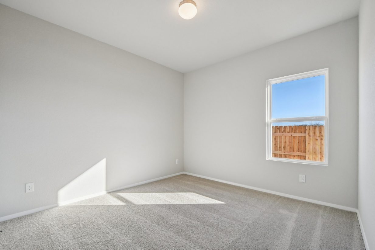 Image of a bedroom with grey walls, tan carpeting and a window