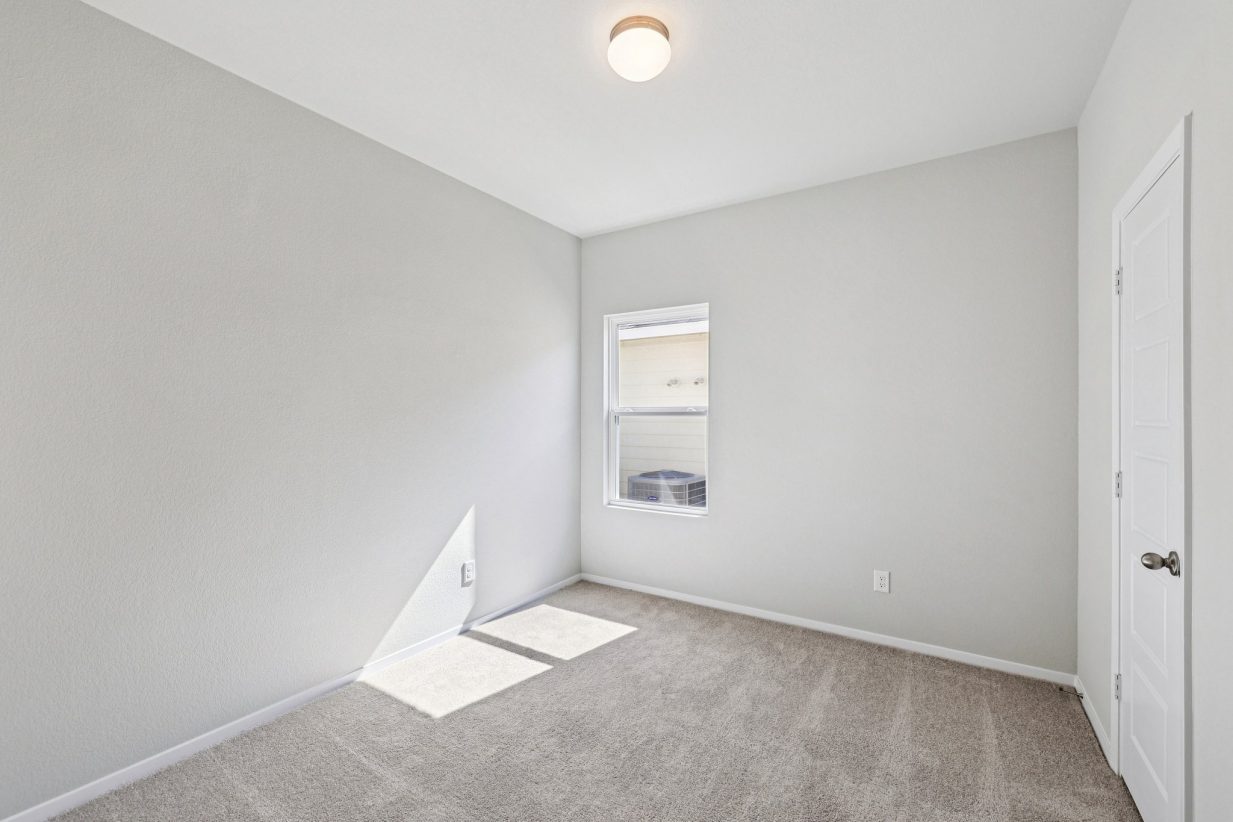 Image of a bedroom with grey walls, windows, white trim, and tan carpeting