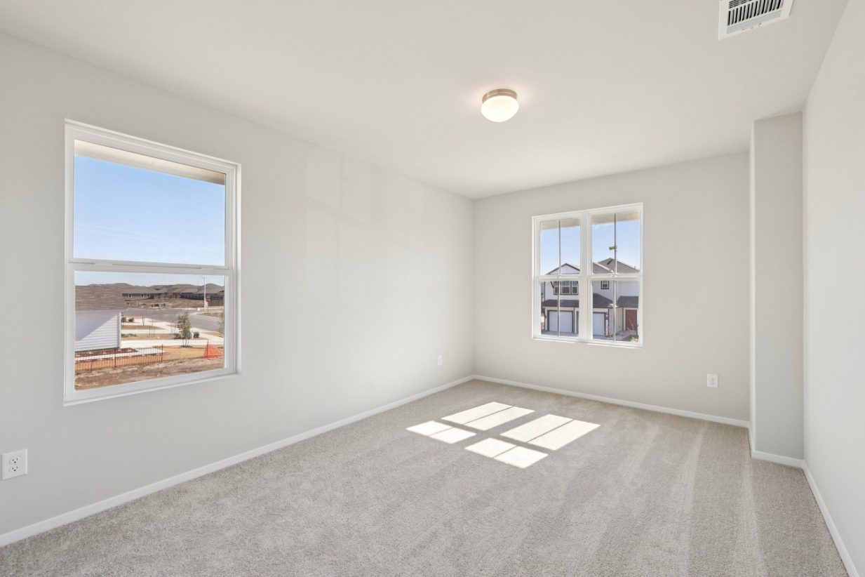 Image of a bedroom with grey walls, tan carpeting, windows and white trim