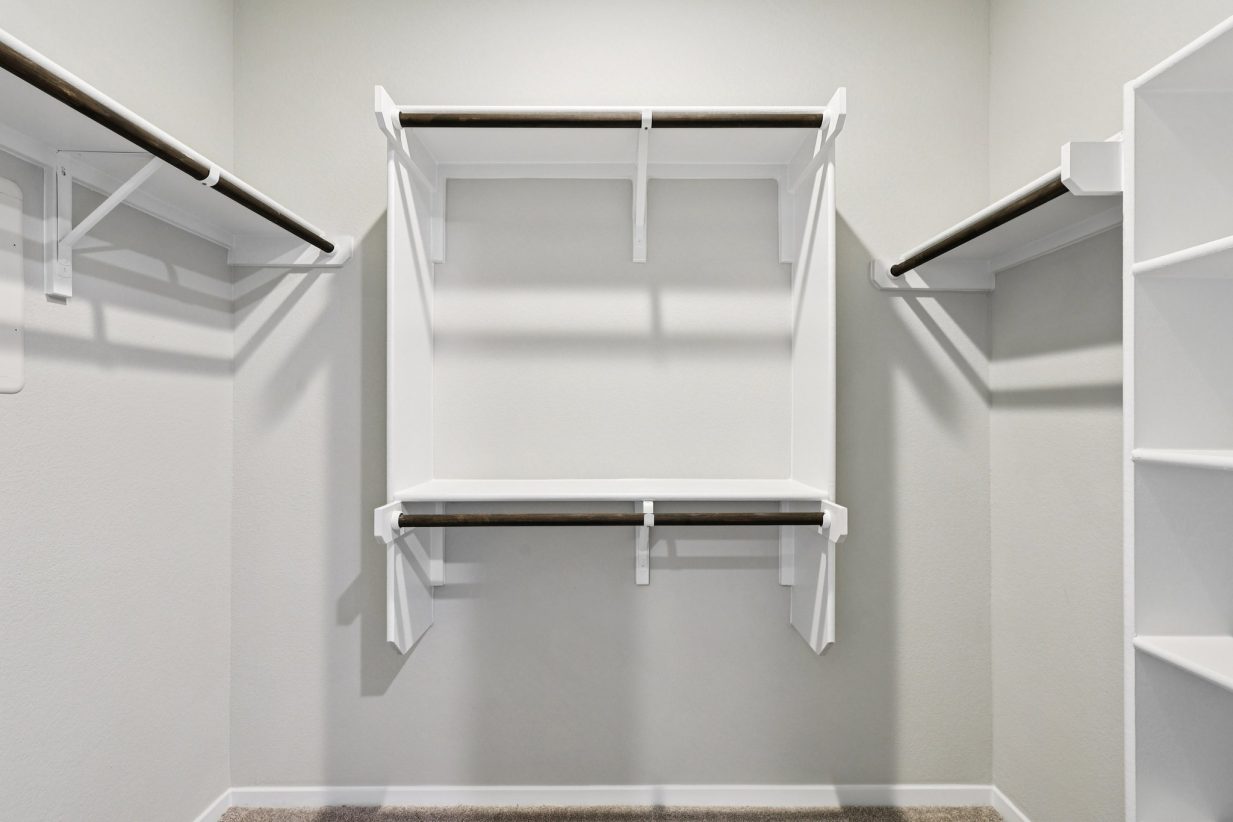 Image of a walk-in closet with shelves and rods