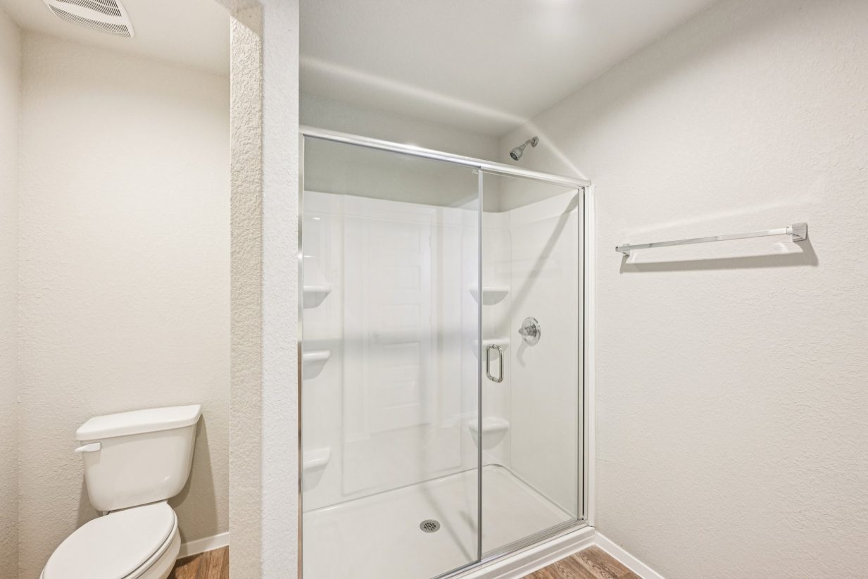 Image of a primary bathroom with a walk-in shower and water closet
