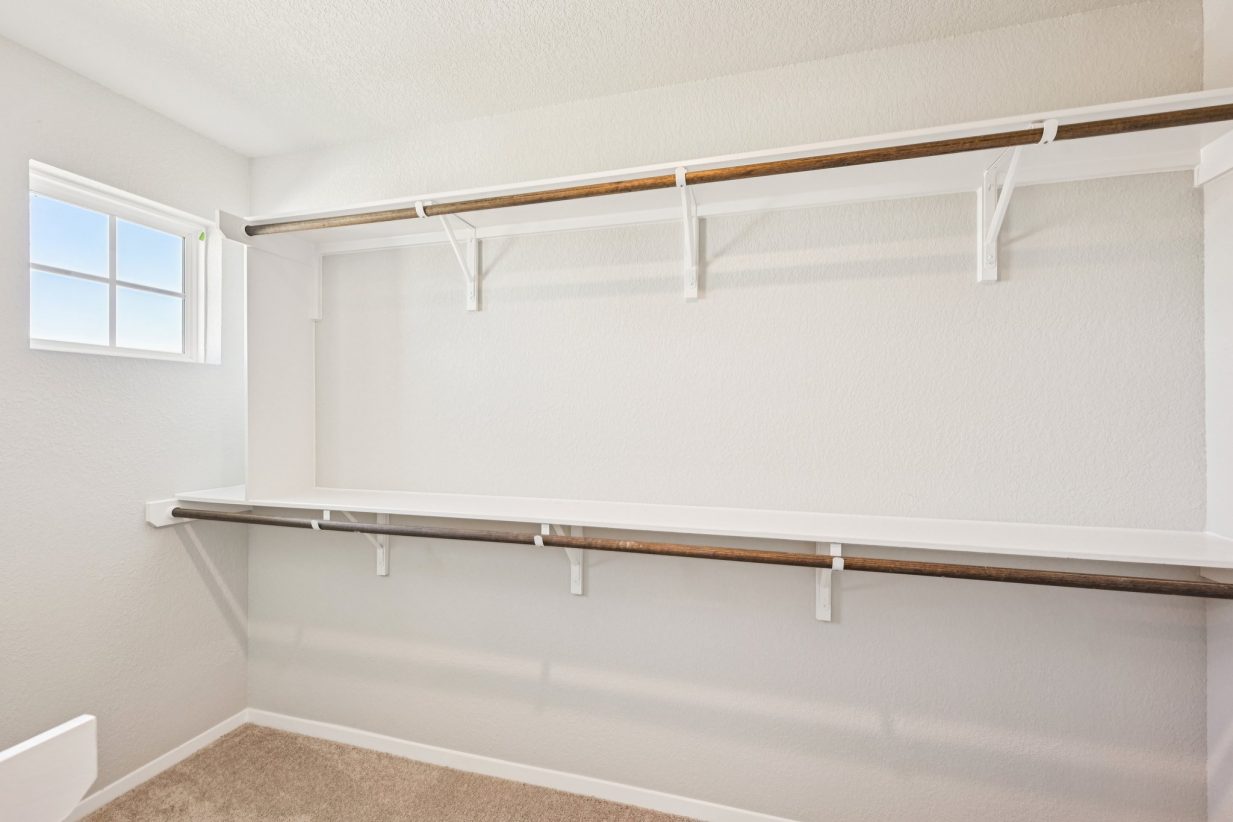 Image of a primary closet with white shelves