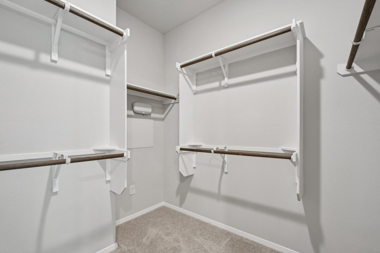 Image of a primary closet with white shelves