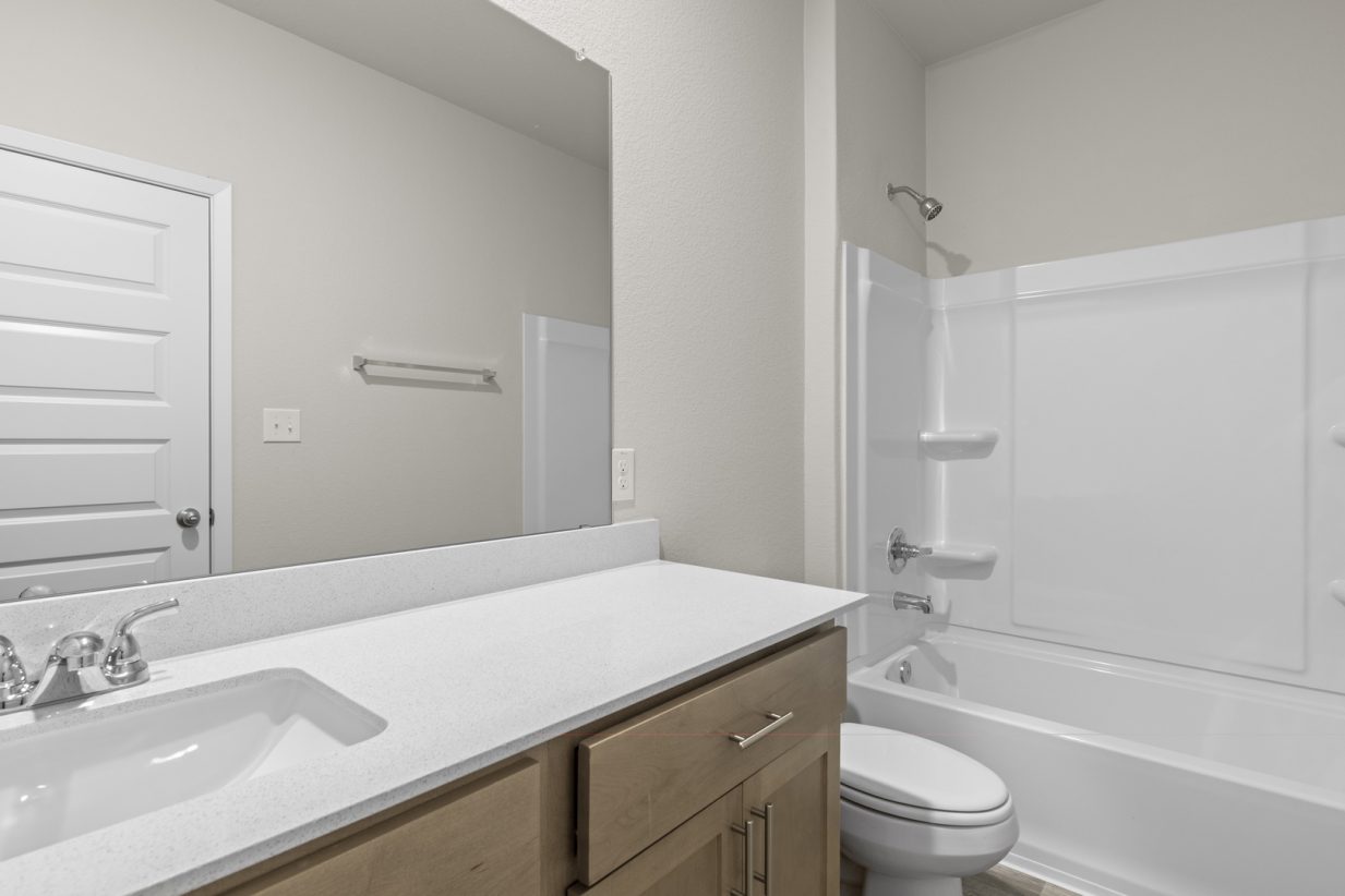 Image of a bathroom with a white dual vanity, a large mirror, and a white shower with a tub