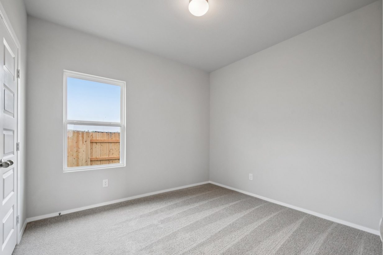 Image of a bedroom with grey walls, tan carpeting and a window