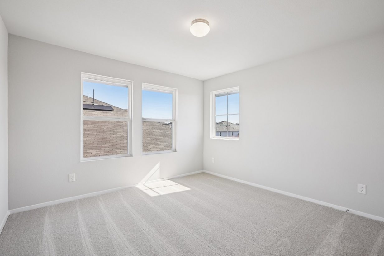 Image of a bedroom with grey walls, tan carpeting, windows and white trim