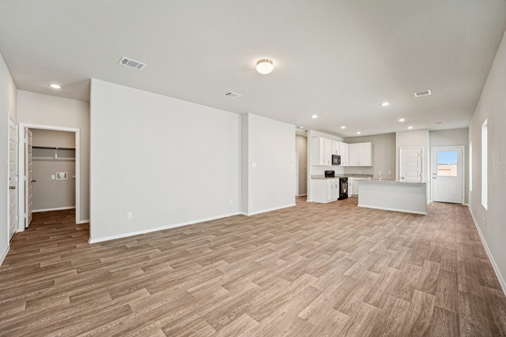 Image of a living and dining area with vinyl flooring, grey walls and windows