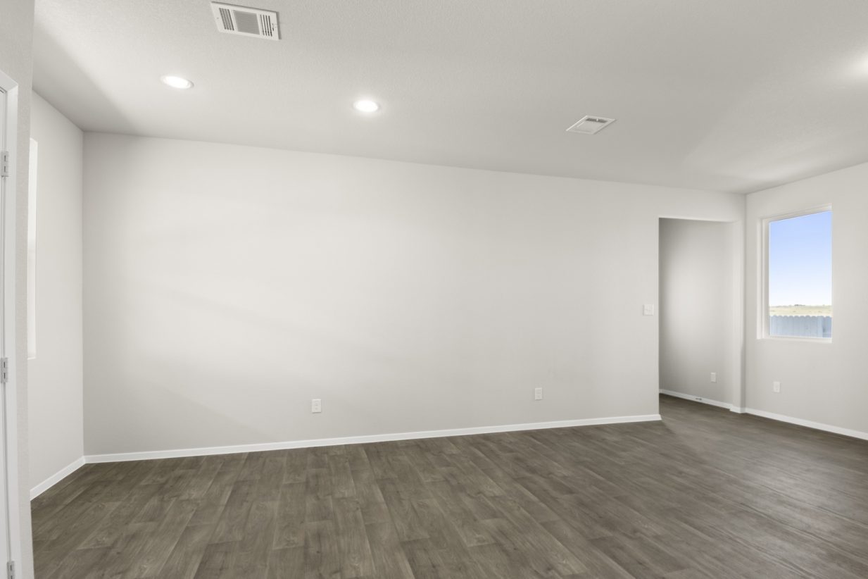 Image of a dining room with light grey walls, dark brown vinyl flooring, and white trim