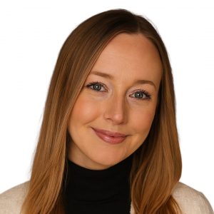 Image of smiling woman with auburn hair, black shirt, and tan sweater