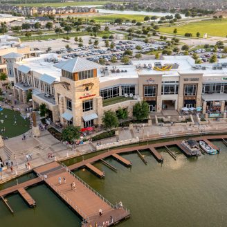 Evening view of upscale shopping and dining restaurants at The Boardwalk in Cypress, Texas near Brohn Homes.