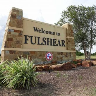 Fulshear People walking along a quaint downtown Fulshear street lined with historic buildings, boutiques, and restaurants.